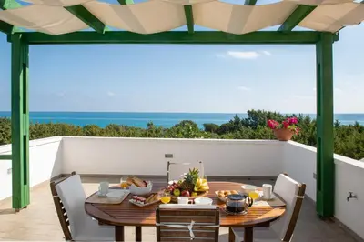 a dining room with a table and a view of the ocean at Beachfront Villa SeaShell Superior in Gennadi