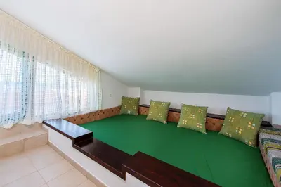 a living room with a couch with green cushions at Beachfront Villa SeaShell Superior in Gennadi