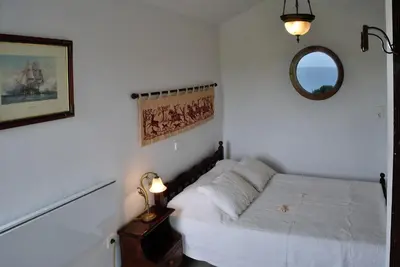 a bedroom with a white bed and a mirror at Beachfront Villa SeaShell Superior in Gennadi
