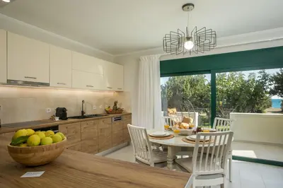 a kitchen with a table with a bowl of fruit on it at Beachfront Villa SeaShell Superior in Gennadi
