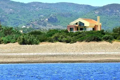 a house on a beach next to a body of water at Beachfront Villa SeaShell Superior in Gennadi