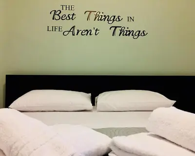 a bedroom with a bed with the words the best things in life arent things at Amaradios in Rhodes Town