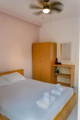 a bedroom with a white bed with a ceiling fan at Amaradios in Rhodes Town