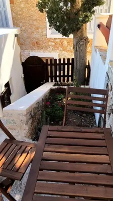 two wooden benches sitting next to a tree at Villetta Erato-picturesque studio in Halki