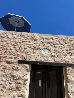 a clock on the side of a building with an umbrella at Villetta Erato-picturesque studio in Halki