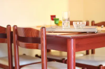 a wooden table with two glasses on top of it at Eos Studios in Symi