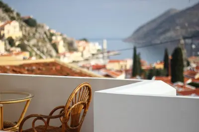 two chairs and a table on a balcony with a view at Eos Studios in Symi