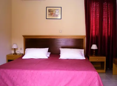 a bedroom with a pink bed with two pillows at Eos Studios in Symi