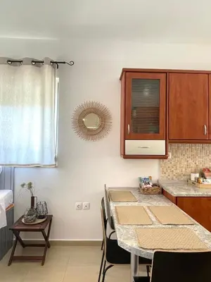 a kitchen with a table with chairs and a mirror at Summer Breeze Villa in Afantou