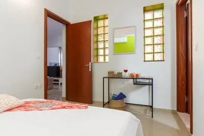 a bedroom with a bed and a table and windows at Summer Breeze Villa in Afantou