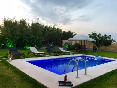 a pool in a yard with chairs and a gazebo at Summer Breeze Villa in Afantou