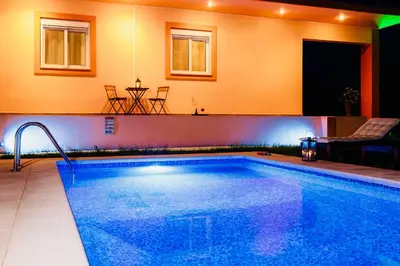 a large swimming pool in a room with a table at Summer Breeze Villa in Afantou