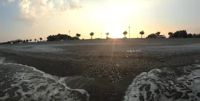 a beach with the sun setting in the background at Summer Breeze Villa in Afantou