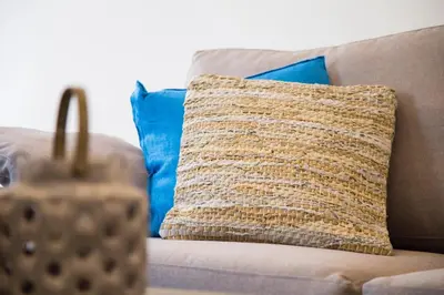 a pillow sitting on a couch with blue pillows at Elenis Philoxenia in Ixia
