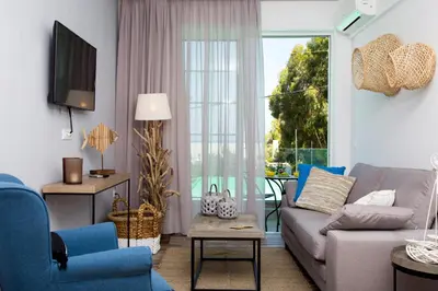 a living room with a couch and a tv at Elenis Philoxenia in Ixia