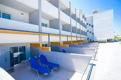 a row of blue chairs on a building at Tsampika Hotel Faliraki in Faliraki