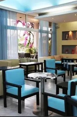 a restaurant with blue chairs and tables in a room at Rhodian Sun Hotel in Paradeísion