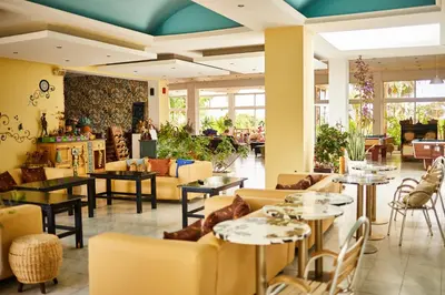 a lobby with couches and tables in a restaurant at Rhodian Sun Hotel in Paradeísion