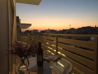 a table with a wine bottle and glasses on a balcony at Zelos Rhodian House in Rhodes Town