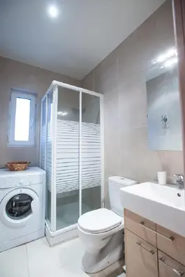 a bathroom with a toilet and a washing machine at Zelos Rhodian House in Rhodes Town