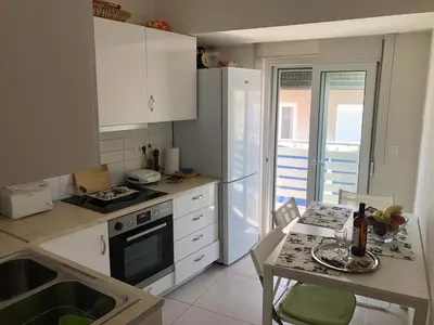 a kitchen with white cabinets and a table with a tableablish at Zelos Rhodian House in Rhodes Town