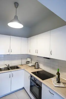 a kitchen with white cabinets and a sink at Zelos Rhodian House in Rhodes Town