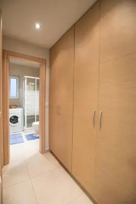 a bathroom with wooden cabinets and a toilet at Zelos Rhodian House in Rhodes Town