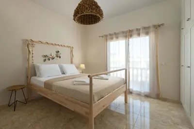a bedroom with a bed and a large window at Evelyn Villa in Archangelos