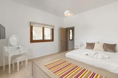 a bedroom with a bed and a desk and a mirror at Evelyn Villa in Archangelos