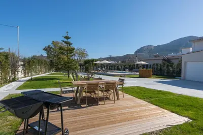 a wooden deck with a table and chairs and a grill at Evelyn Villa in Archangelos