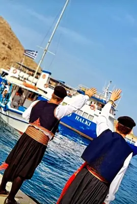two men are standing near a boat in the water at Villa Cassandra in Halki