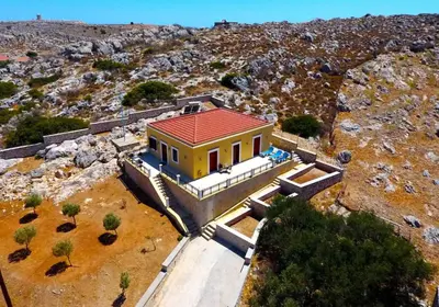 a house with a red roof on a mountain at Villa Cassandra in Halki
