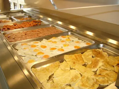 a buffet line with many trays of food at Rhodian Rose Hotel in Faliraki