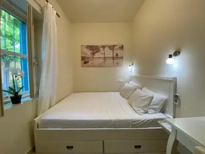 a small bed in a room with a window at Maison Masse - Historic Residence with Private Courtyard in Rhodes Town