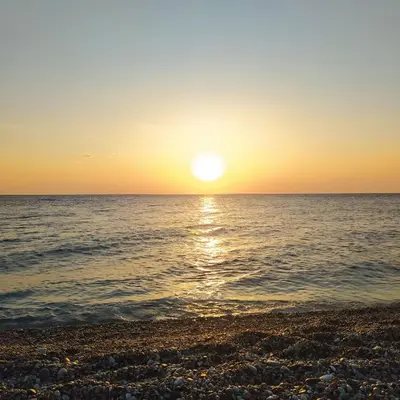 a sunset over the ocean on a beach at Maison Masse - Historic Residence with Private Courtyard in Rhodes Town
