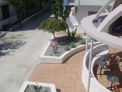 a walkway with flowers and plants on a building at Omiros in Faliraki