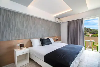 a hotel room with a bed and a balcony at CasaStavris - Aparts & Pool Suites in Faliraki