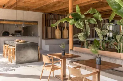 a kitchen with wooden tables and chairs and plants at Lindos Aqua Terra in Líndos