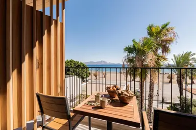 a table on a balcony with a view of the ocean at Lindos Aqua Terra in Líndos