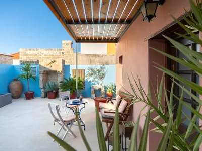 a patio with chairs and tables and plants at Colours - Old Town - Studios in Rhodes Town