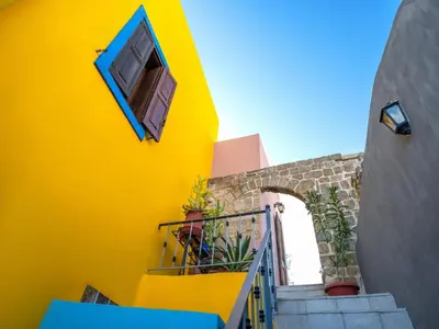 a yellow building with stairs and a window at Colours - Old Town - Studios in Rhodes Town