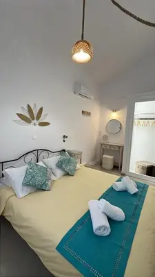a bedroom with a large bed with two pillows at Taxiarchis in Symi