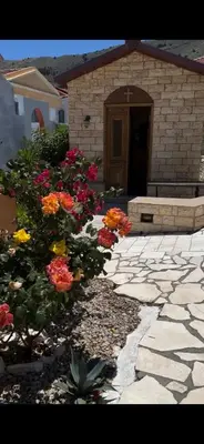a garden with flowers in front of a building at Taxiarchis in Symi