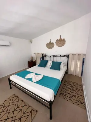 a bedroom with a bed with blue and white sheets at Taxiarchis in Symi