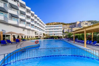 a swimming pool in a hotel with chairs and a building at Lito Hotel in Ixia