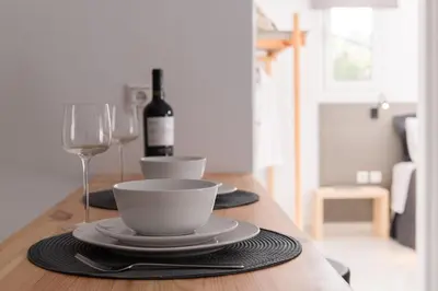 a wooden table with a cup and a wine glass at L & C Boutique Apartments in Kremasti