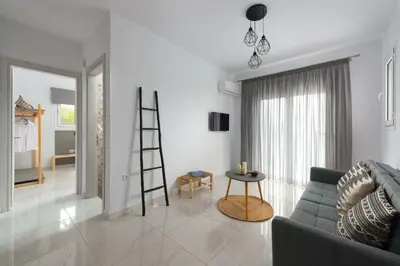 a living room with a ladder and a couch at L & C Boutique Apartments in Kremasti