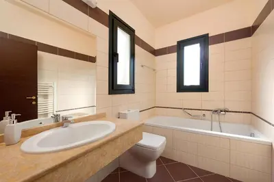 a bathroom with a sink and a tub and a toilet at Seven Springs Villas Artemis Villa in Kolimbia
