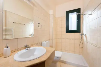 a bathroom with a sink and a shower and a toilet at Seven Springs Villas Artemis Villa in Kolimbia