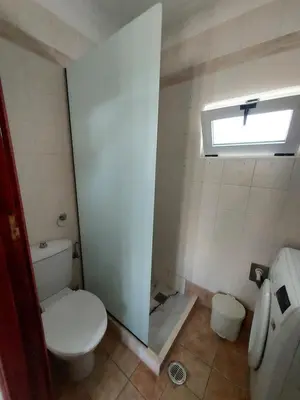a small bathroom with a toilet and a window at Anastasia's garden house in Ialyssos